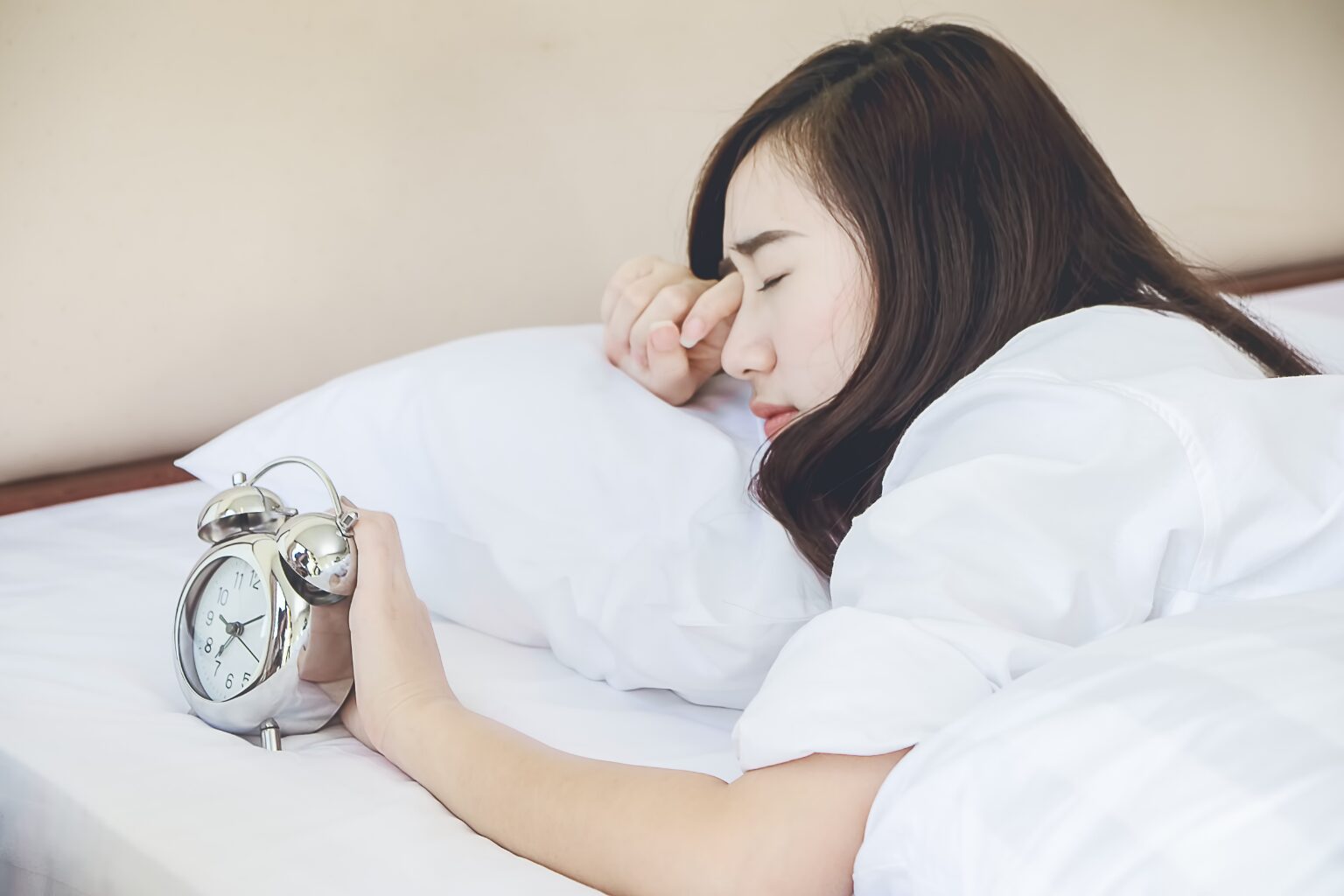目覚ましに起こされた女性