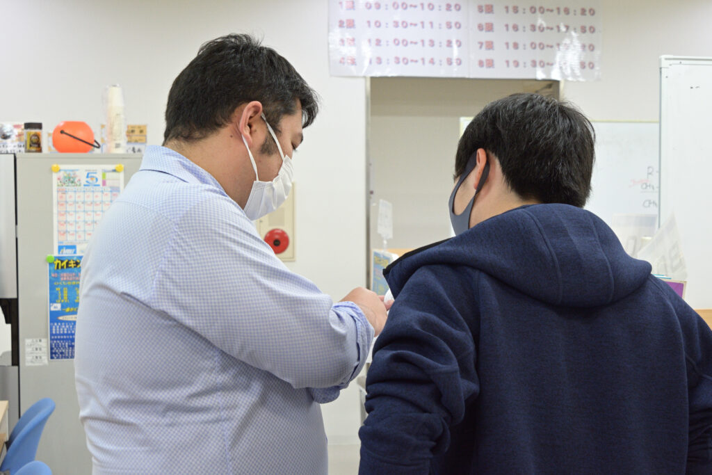 男性講師と男子高校生のチューターの様子