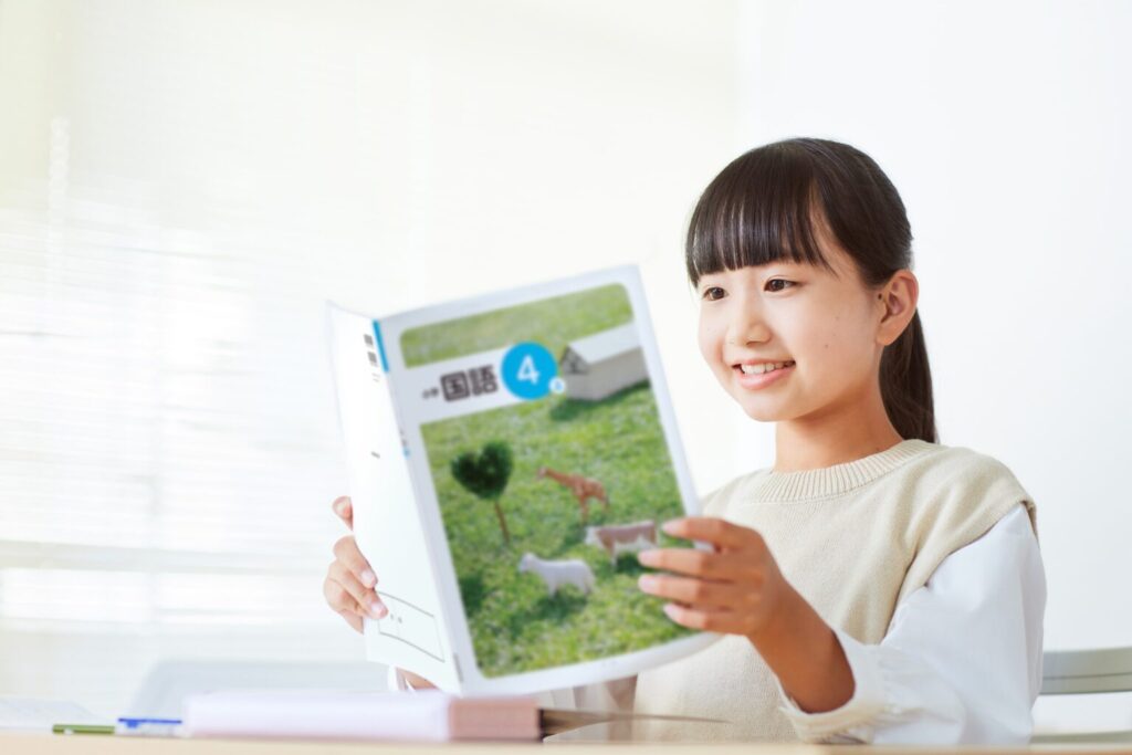 国語の教科書を読んでいる女子小学生