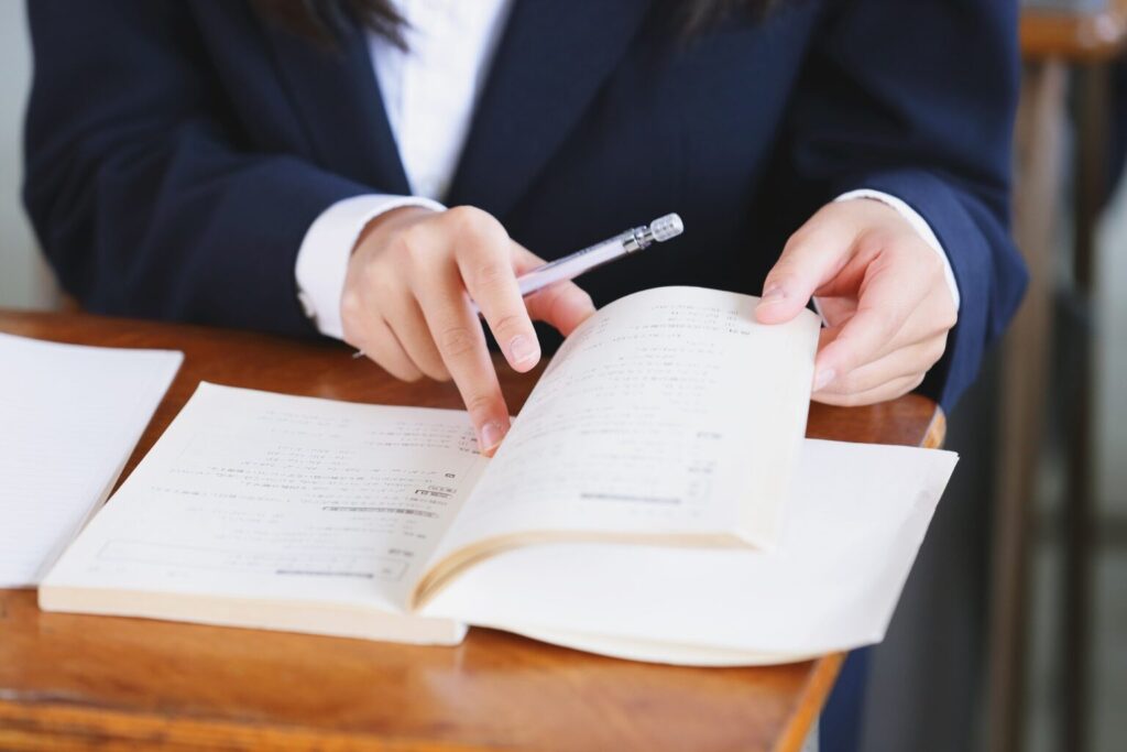 教科書を捲る生徒の手元